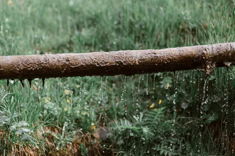 Tubería oxidada perdiendo agua gota a gota por varios puntos, una fuga de agua a la vista