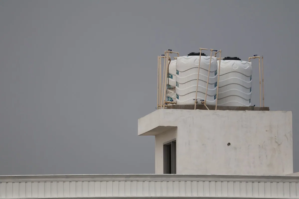 Depósitos de agua de plástico con sus tuberías en la azotea de un edificio