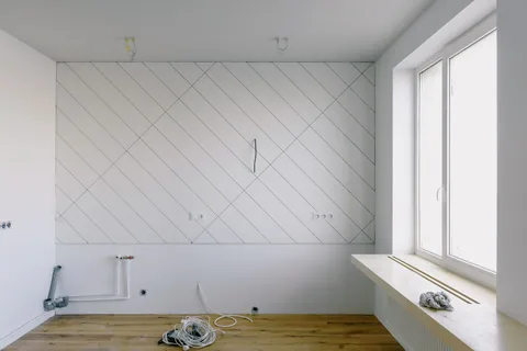 Instalación de fontanería nueva en una cocina en obra, con las tomas de agua y el desagüe preparados en la pared